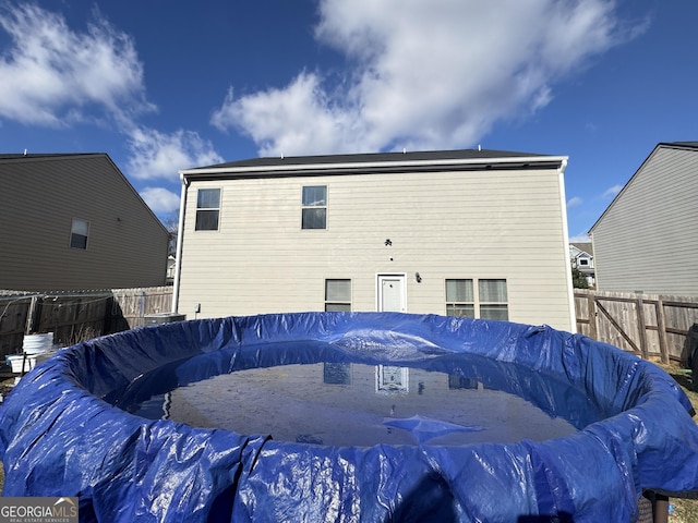 back of house with a covered pool