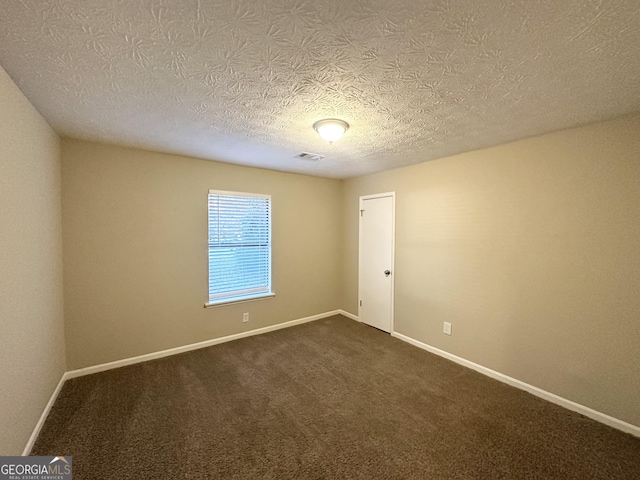 carpeted empty room with a textured ceiling