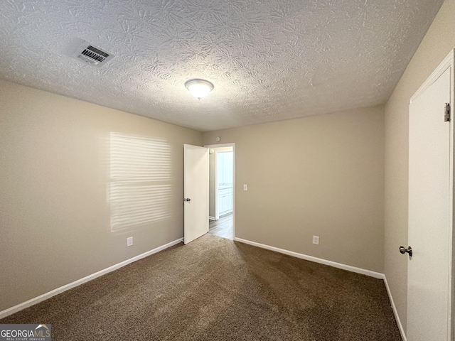 carpeted spare room with a textured ceiling