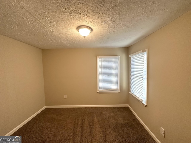 spare room with a textured ceiling and carpet floors