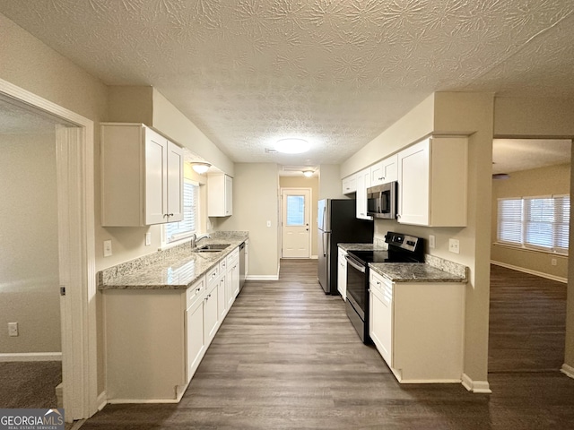 kitchen featuring stainless steel appliances, white cabinetry, and dark hardwood / wood-style floors