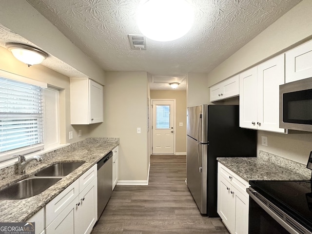 kitchen featuring sink, dark hardwood / wood-style floors, a textured ceiling, white cabinetry, and stainless steel appliances