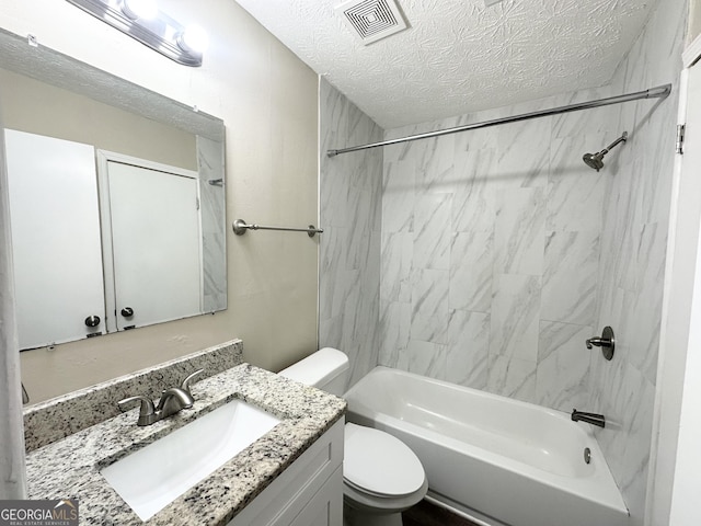 full bathroom with vanity, tiled shower / bath combo, a textured ceiling, and toilet