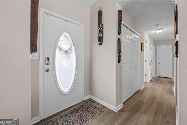 foyer with wood-type flooring and a textured ceiling