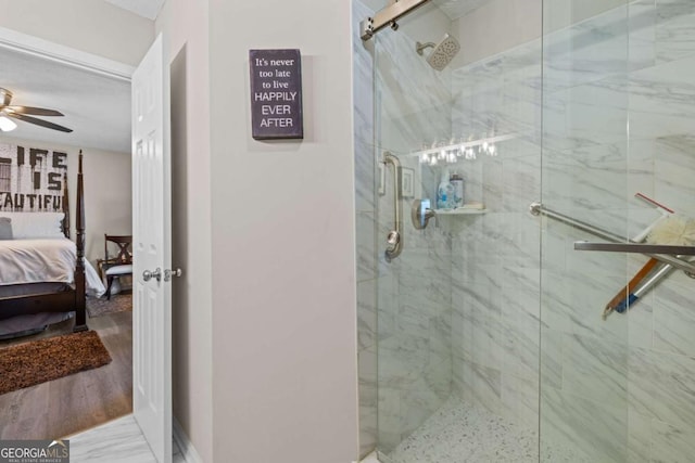 bathroom with hardwood / wood-style flooring, ceiling fan, and an enclosed shower