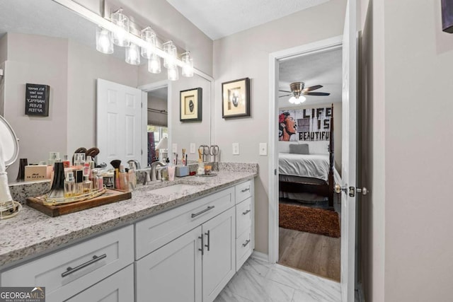 bathroom with ceiling fan, a textured ceiling, and vanity