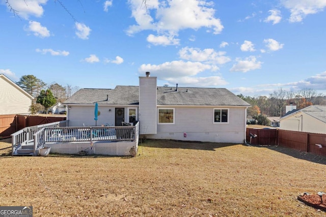 back of property featuring a wooden deck and a yard