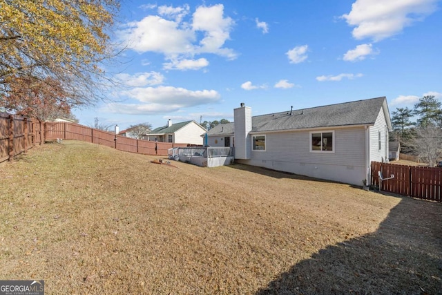 back of property featuring a yard and a covered pool