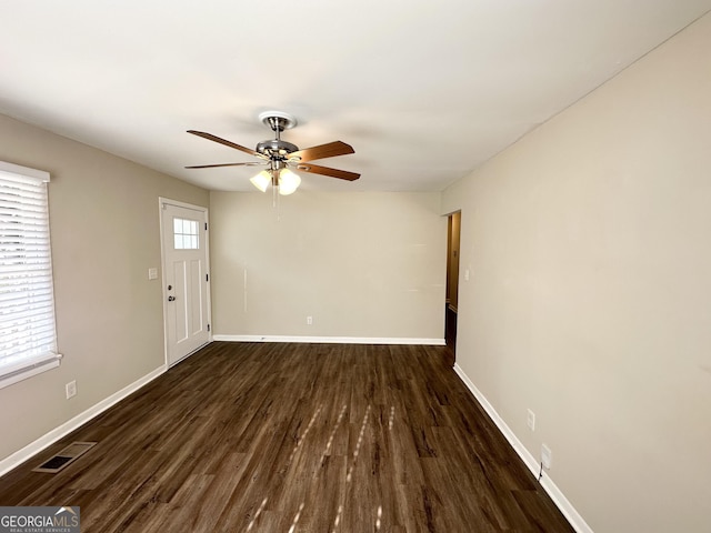 empty room with ceiling fan and dark hardwood / wood-style floors