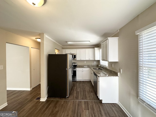 kitchen with sink, dark wood-type flooring, stainless steel appliances, plenty of natural light, and white cabinets