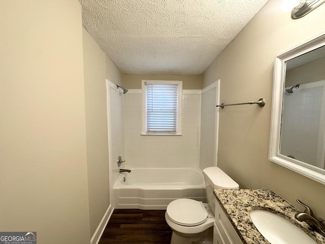 full bathroom with vanity, tiled shower / bath combo, toilet, a textured ceiling, and wood-type flooring