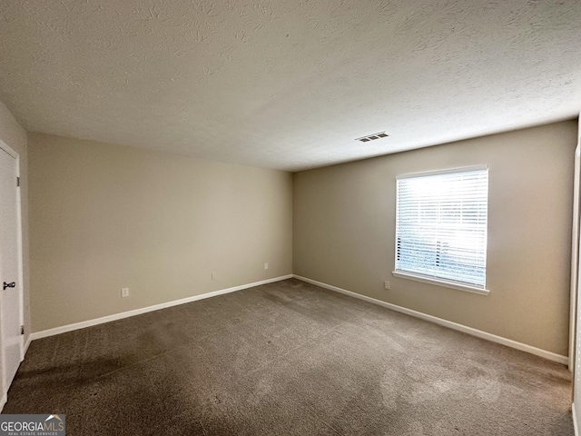 empty room with carpet flooring and a textured ceiling