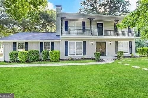 view of property with a front yard and a balcony