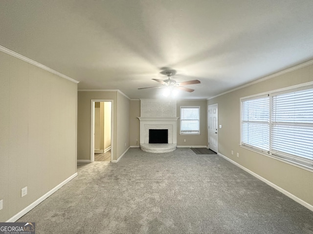 unfurnished living room featuring carpet, a fireplace, crown molding, and ceiling fan