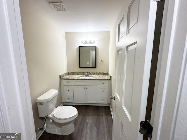 bathroom with vanity, wood-type flooring, and toilet