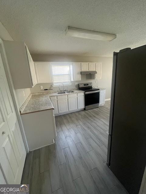 kitchen featuring sink, white cabinets, stainless steel appliances, and a textured ceiling