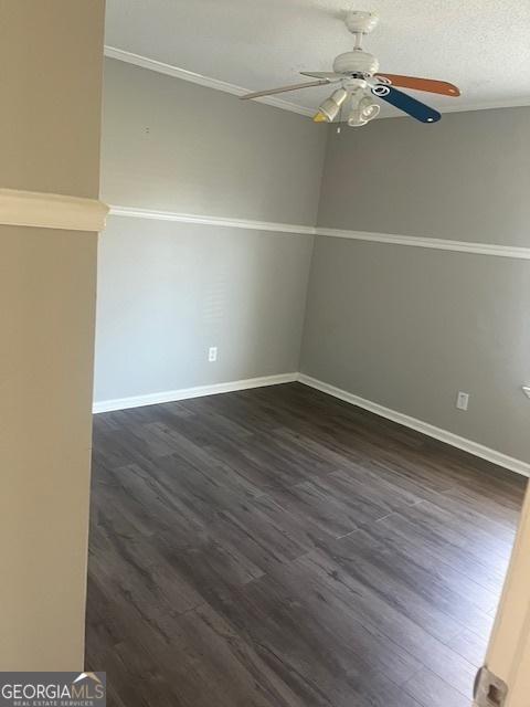 spare room featuring dark hardwood / wood-style floors, ceiling fan, and a textured ceiling