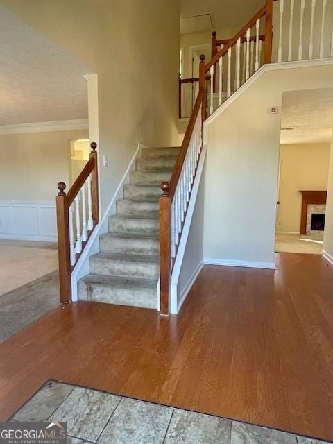 stairs featuring hardwood / wood-style floors and ornamental molding