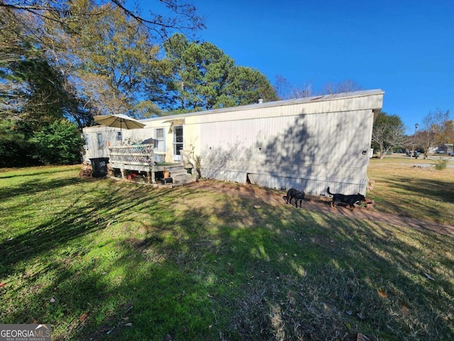 rear view of property featuring a yard and a deck