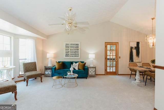 living room featuring ceiling fan with notable chandelier, carpet floors, and vaulted ceiling