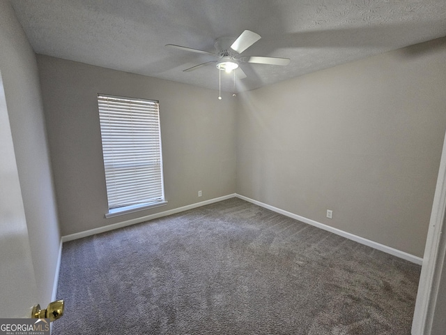 empty room featuring dark colored carpet, a textured ceiling, and ceiling fan