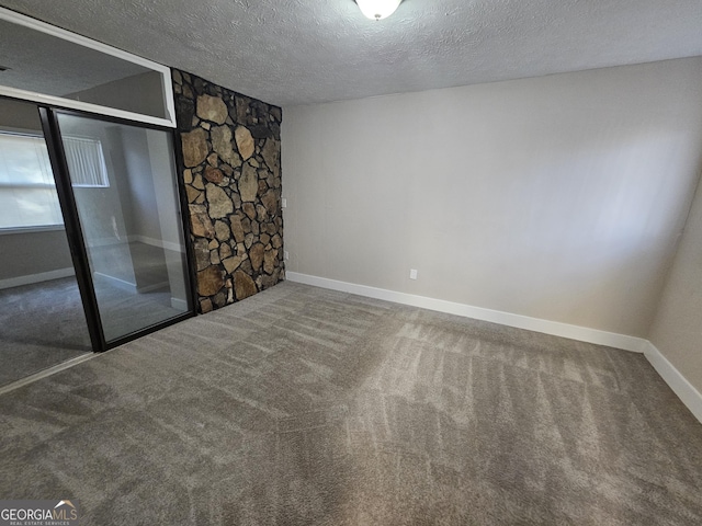 spare room featuring carpet flooring and a textured ceiling