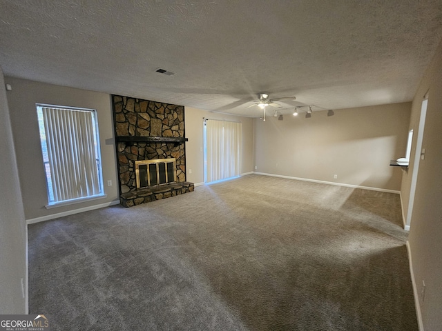 unfurnished living room featuring a fireplace, a textured ceiling, carpet floors, and ceiling fan