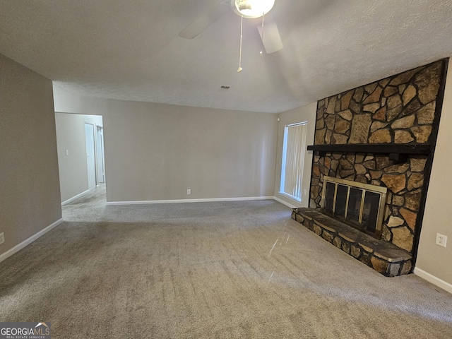 unfurnished living room with ceiling fan, a fireplace, carpet, and a textured ceiling