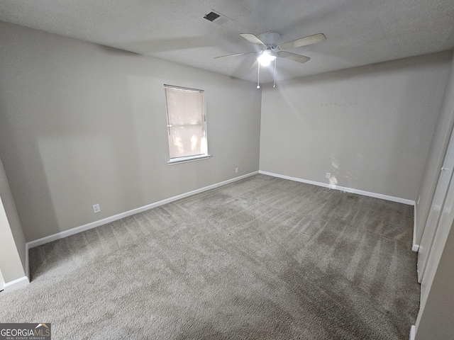 carpeted spare room with ceiling fan and a textured ceiling