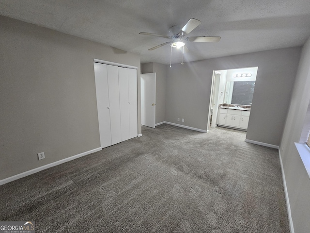 unfurnished bedroom featuring carpet, ceiling fan, ensuite bath, and a closet