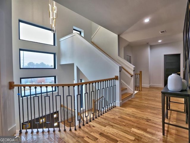 stairway featuring hardwood / wood-style flooring and a towering ceiling