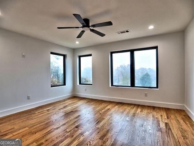 spare room with hardwood / wood-style flooring and ceiling fan