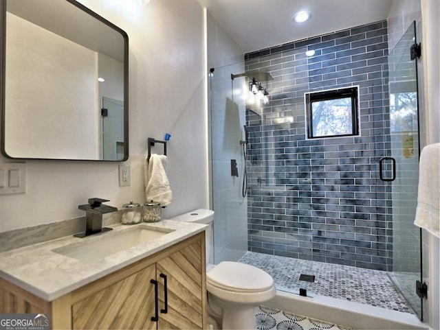 bathroom with vanity, toilet, and a shower with door