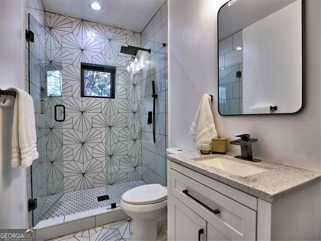 bathroom featuring tile patterned floors, walk in shower, vanity, and toilet