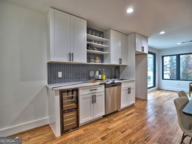 kitchen featuring light hardwood / wood-style flooring, white cabinets, beverage cooler, and stainless steel dishwasher