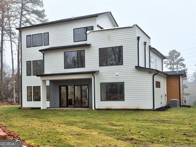 rear view of property featuring a yard and central AC