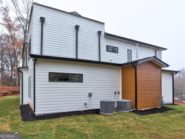 back of house featuring a yard and cooling unit