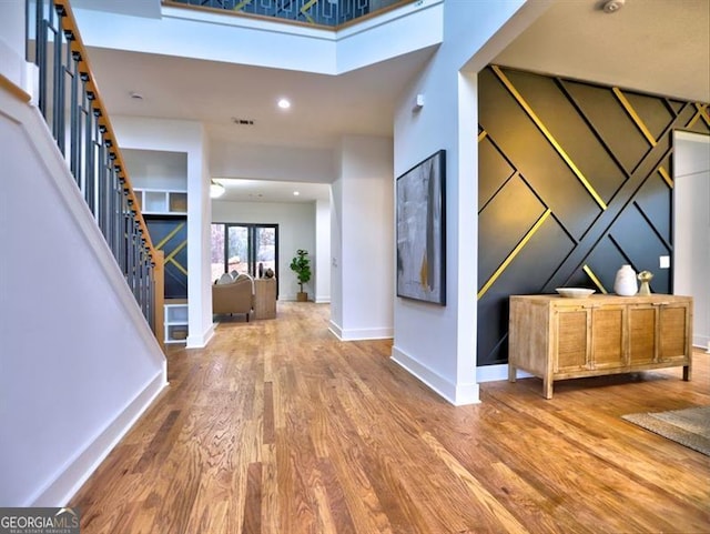 foyer entrance with a towering ceiling and hardwood / wood-style flooring