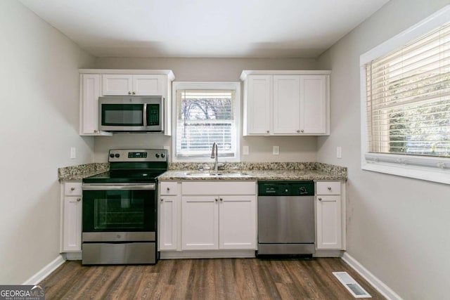 kitchen with a healthy amount of sunlight, sink, white cabinets, and stainless steel appliances