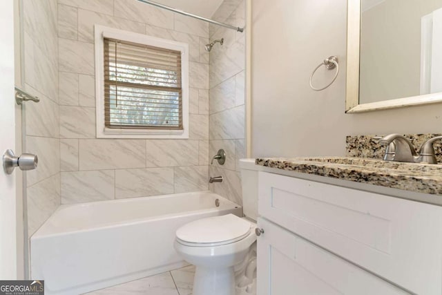 full bathroom featuring toilet, vanity, and tiled shower / bath