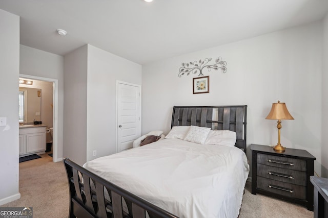 bedroom featuring light carpet and ensuite bath