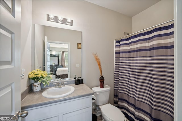 bathroom featuring walk in shower, vanity, and toilet