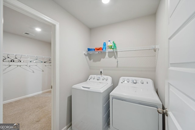 laundry area featuring washing machine and clothes dryer and carpet flooring