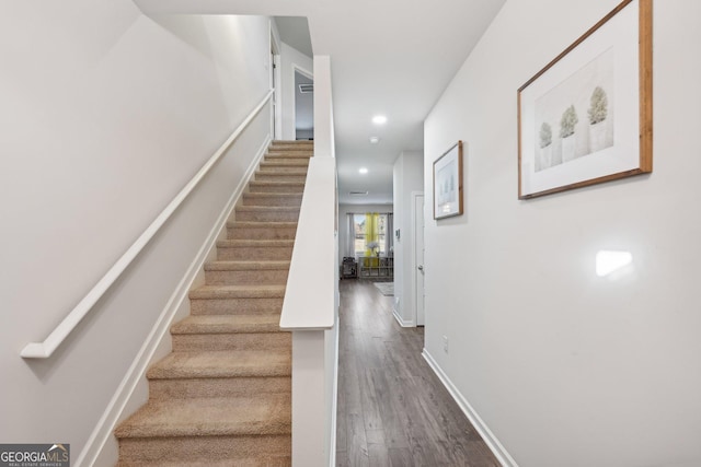 stairs featuring hardwood / wood-style floors