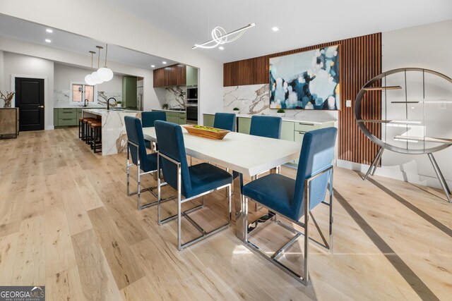 dining area with light wood-type flooring and sink