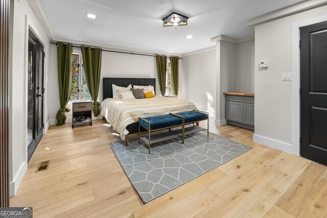 bedroom featuring light hardwood / wood-style floors and ornamental molding