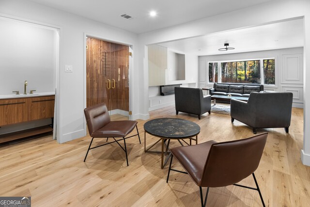 living area featuring sink and light hardwood / wood-style floors