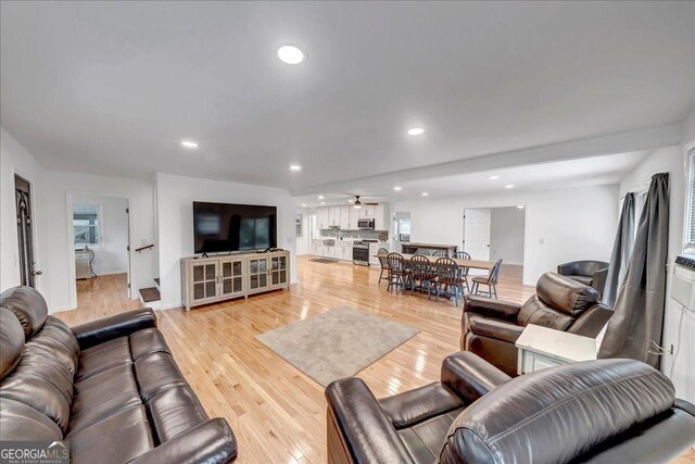 living room with ceiling fan and light wood-type flooring