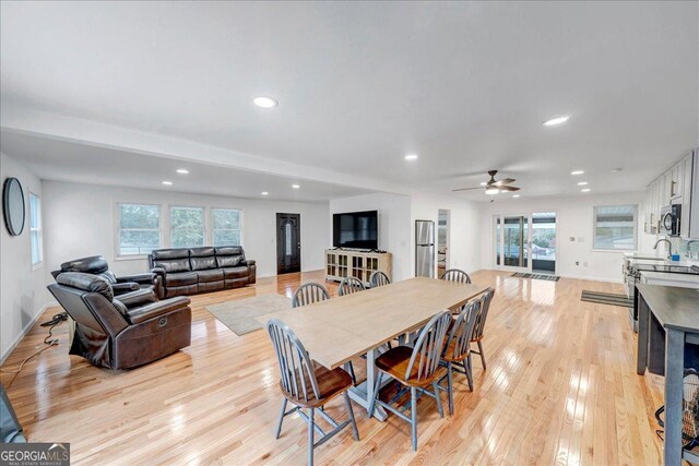 dining space featuring ceiling fan, sink, and light hardwood / wood-style flooring