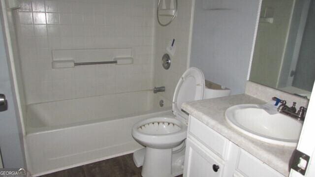 full bathroom featuring vanity, tiled shower / bath combo, hardwood / wood-style flooring, and toilet